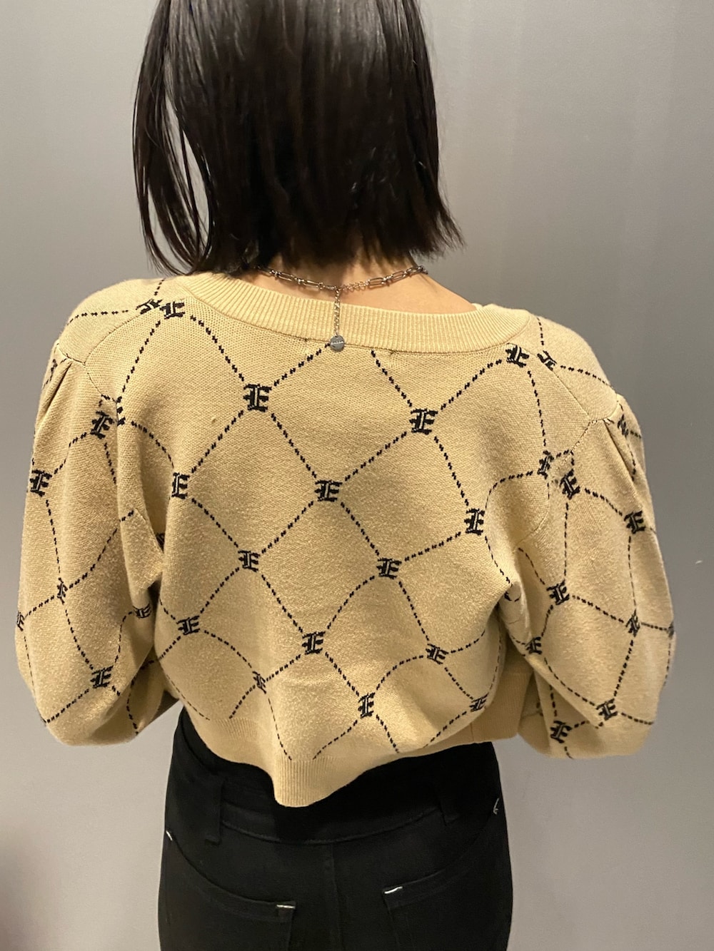 ブラック系のブーツ、ブラック系のデニムパンツ、ベージュ系のニット/セーターを着用したレディースの秋コーディネートの9枚目の写真