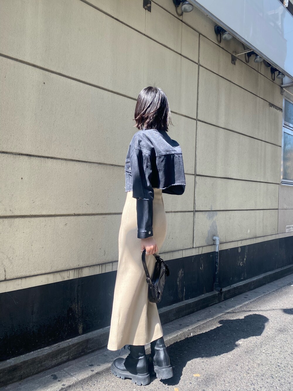 ブラック系のブーツ、ベージュ系のワンピース、ブラック系のデニムジャケットを着用したレディースの春コーディネートの9枚目の写真