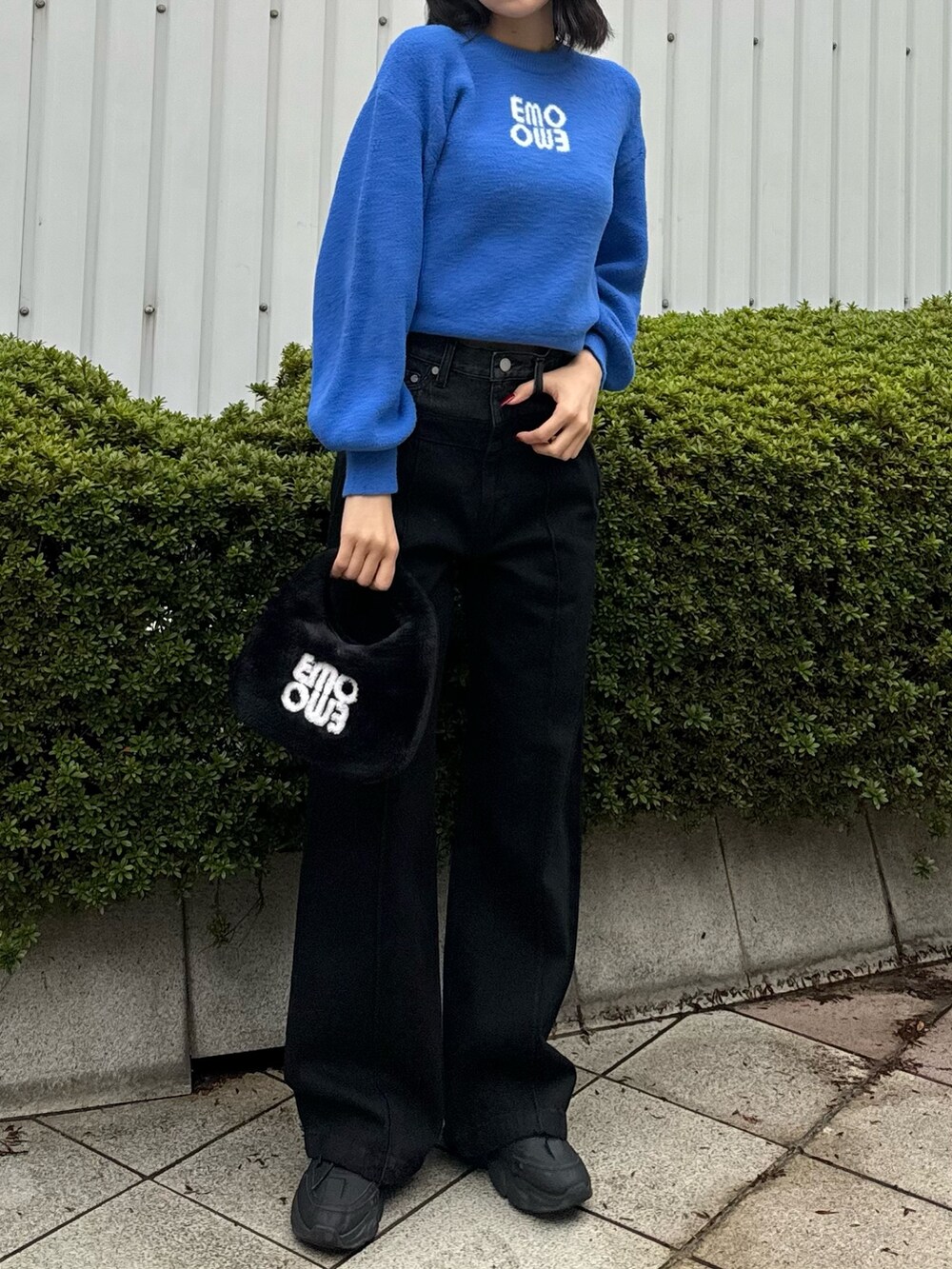 ブルー系のニット/セーター、ブラック系のデニムパンツ、ブラック系のハンドバッグを着用したレディースの冬コーディネートの2枚目の写真