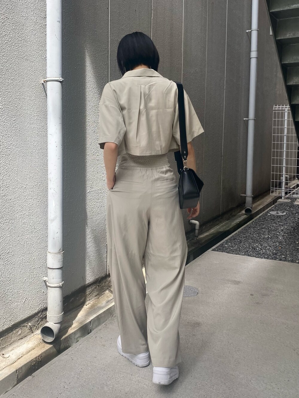 ベージュ系のその他パンツ、ホワイト系のキャミソール、ベージュ系のショルダーバッグを着用したレディースの夏コーディネートの6枚目の写真