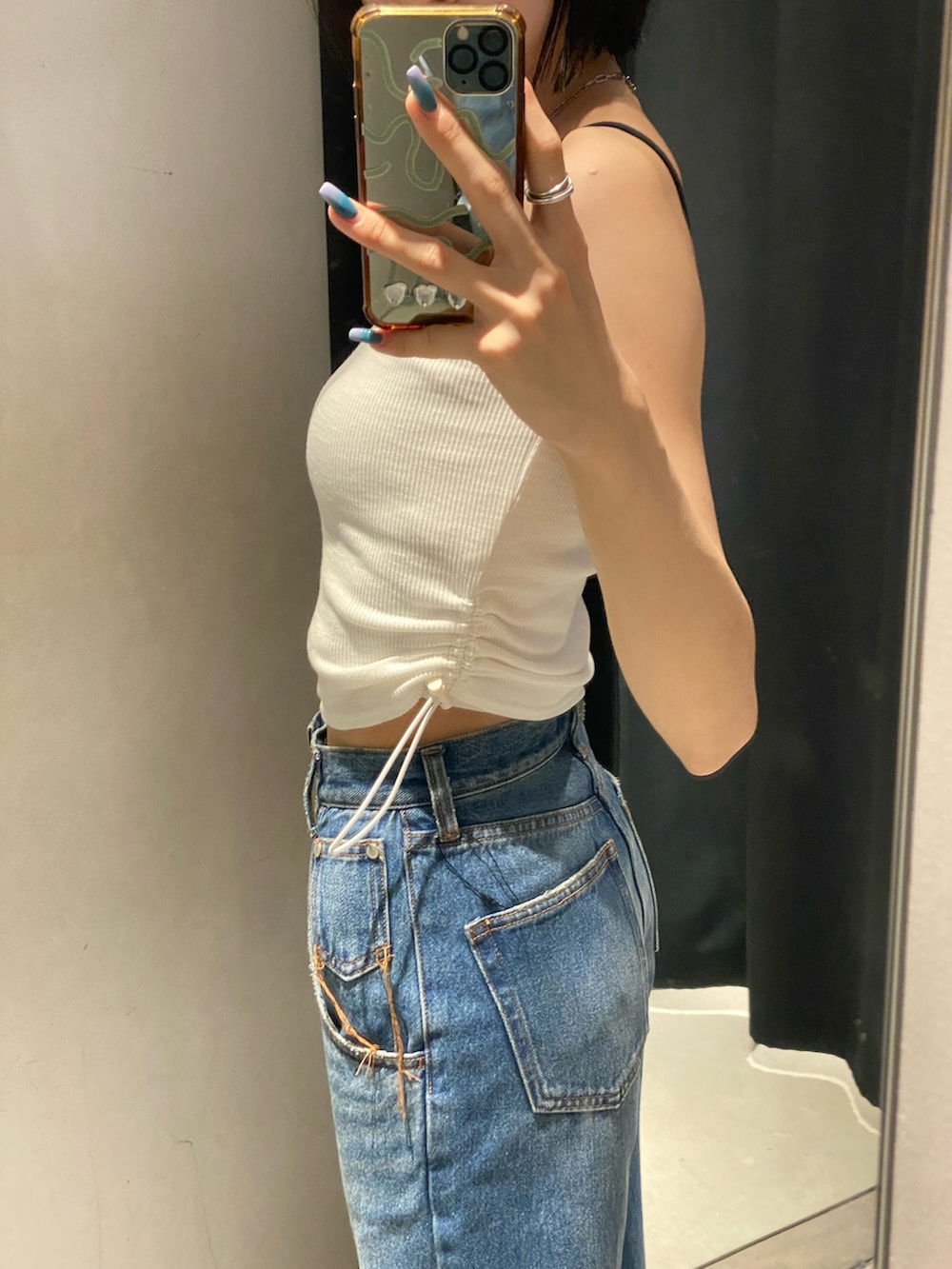 ブラック系のサンダル、ブルー系のデニムパンツ、ホワイト系のTシャツ/カットソーを着用したレディースの夏コーディネートの6枚目の写真