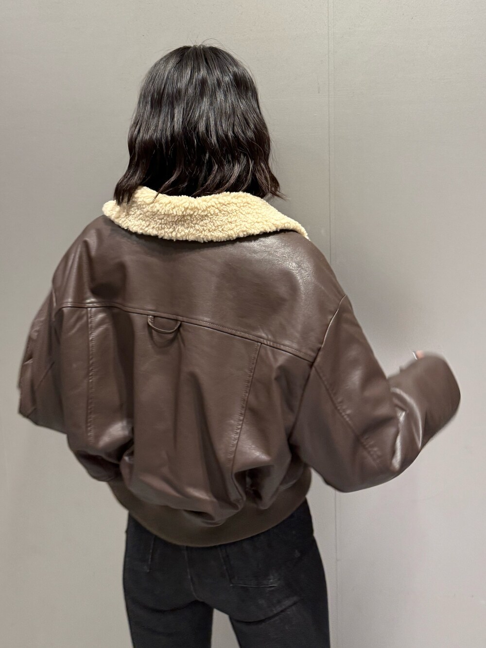 ブラック系のブーツ、ブラック系のデニムパンツ、ブラック系のニット/セーターを着用したレディースの冬コーディネートの9枚目の写真