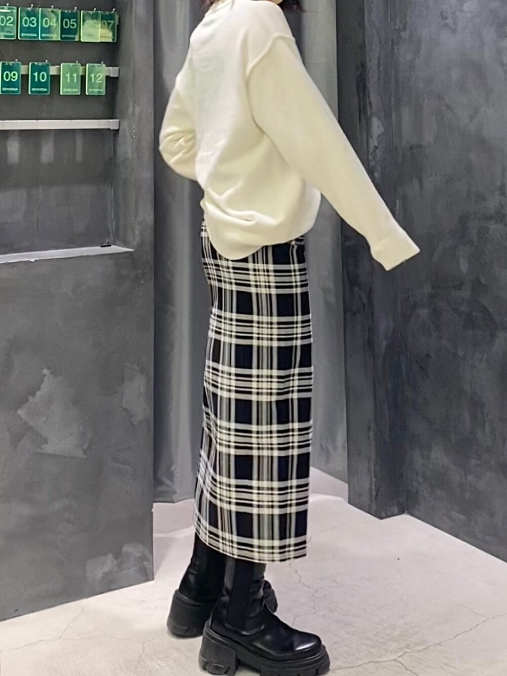 その他のスカート、ホワイト系のニット/セーター、ブラック系のブーツを着用したレディースの冬コーディネートの5枚目の写真