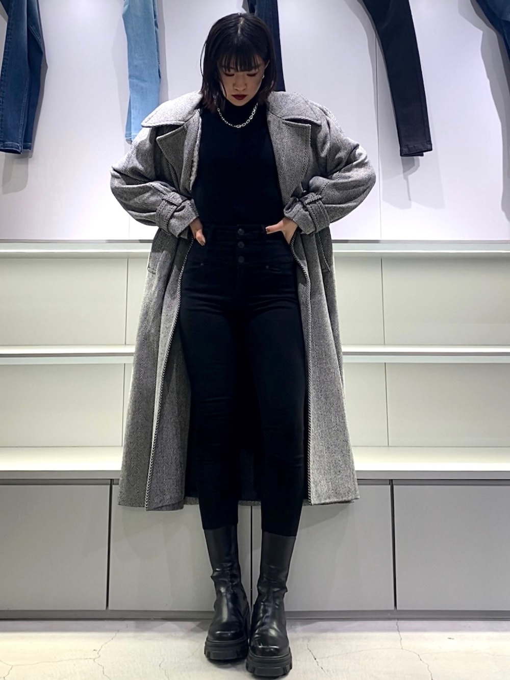 その他のチェスターコート、ブラック系のブーツ、ブラック系のニット/セーターを着用したレディースの秋コーディネートの4枚目の写真