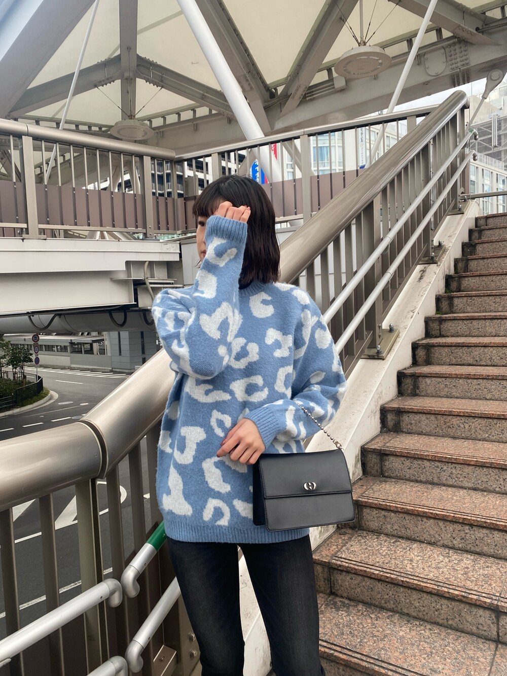 ブルー系のニット/セーター、ブラック系のハンドバッグ、ブラック系のブーツを着用したレディースの冬コーディネートの6枚目の写真