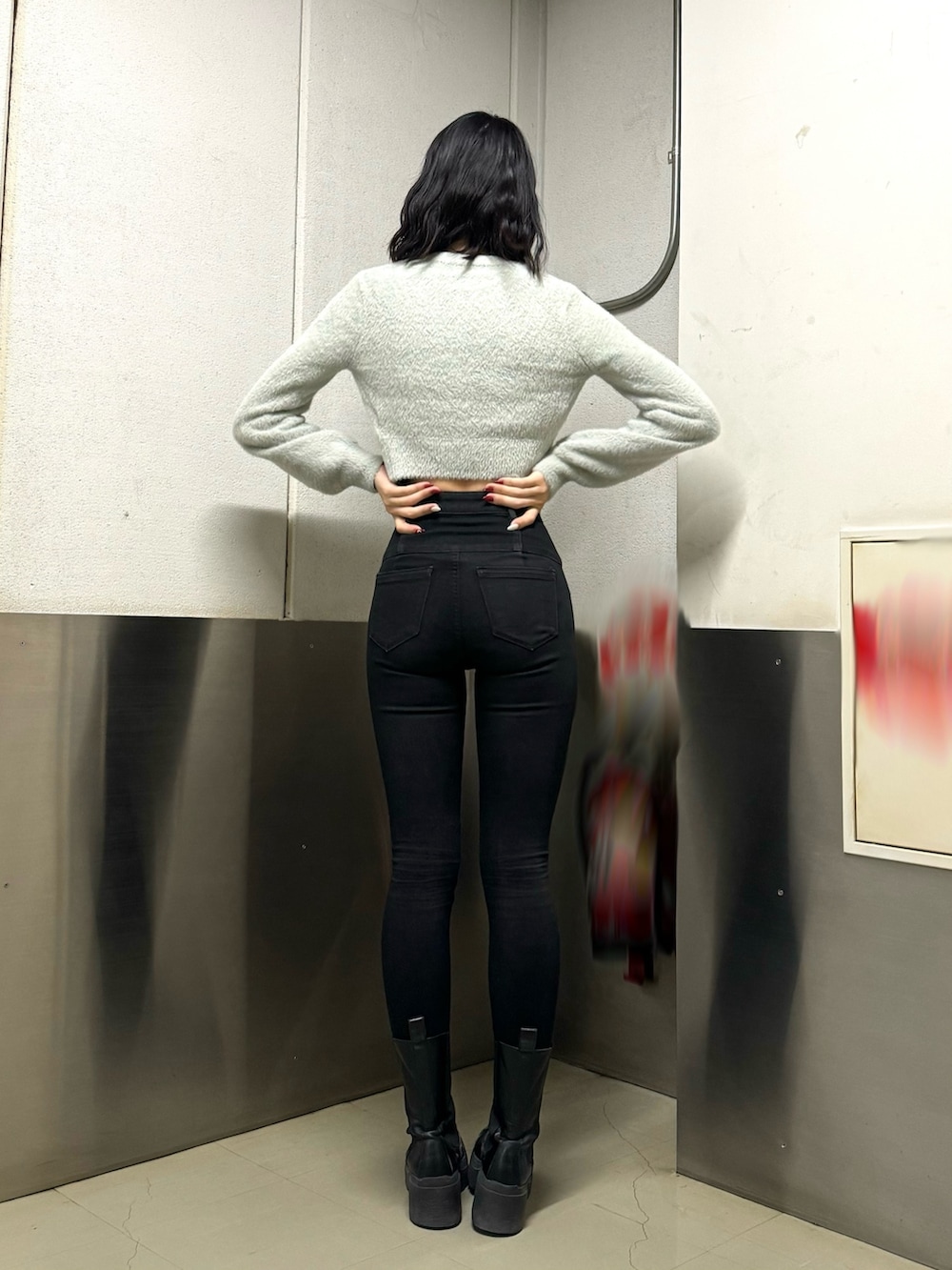 ブラック系のブーツ、ブラック系のデニムパンツ、グレー系のニット/セーターを着用したレディースの冬コーディネートの4枚目の写真