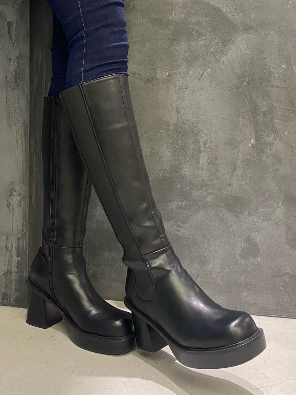 ブラック系のブーツ、その他のテーラードジャケット、ブルー系のデニムパンツを着用したレディースの秋コーディネートの7枚目の写真