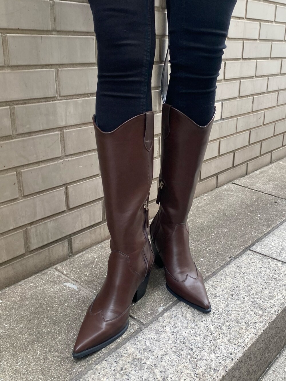 ブラック系のブーツ、ブラック系のデニムパンツ、ホワイト系のブルゾンを着用したレディースの冬コーディネートの8枚目の写真