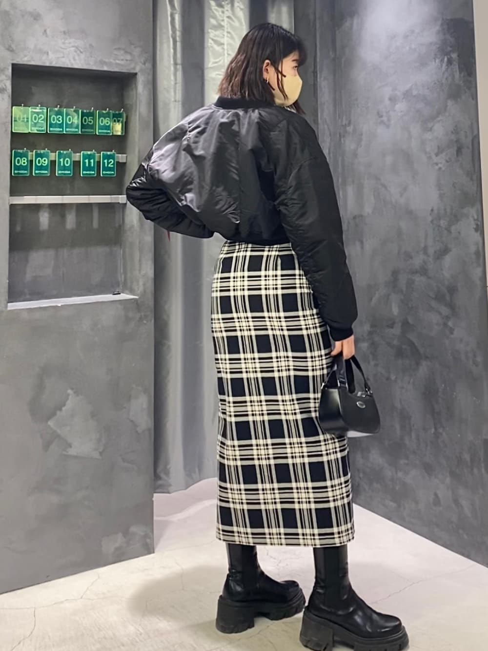 その他のスカート、ブラック系のブーツ、ブラック系のハンドバッグを着用したレディースの冬コーディネートの3枚目の写真