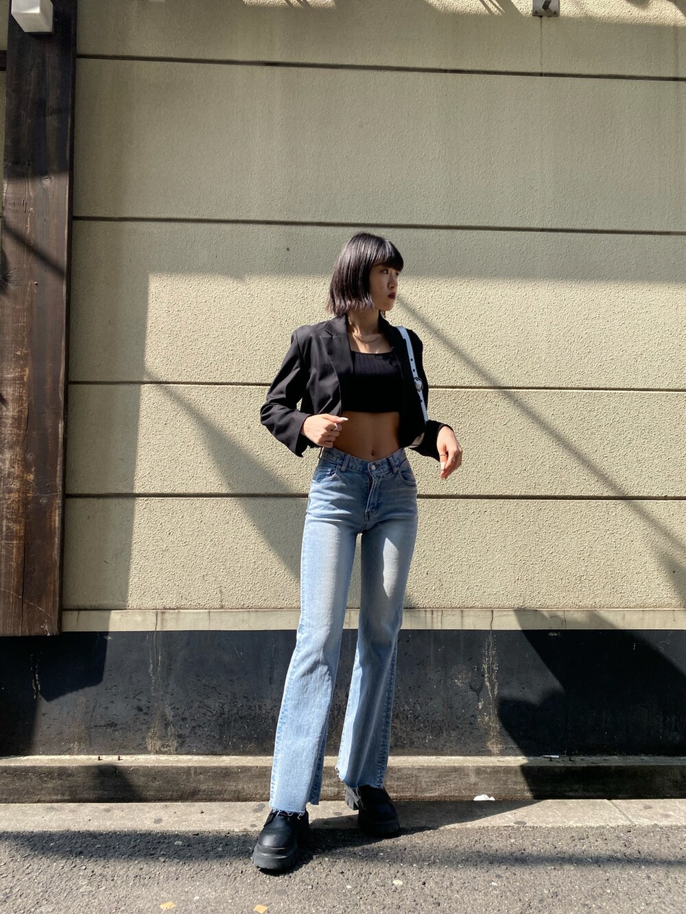 ブラック系のブーツ、ブルー系のデニムパンツ、ブラック系のTシャツ/カットソーを着用したレディースの春コーディネートの2枚目の写真