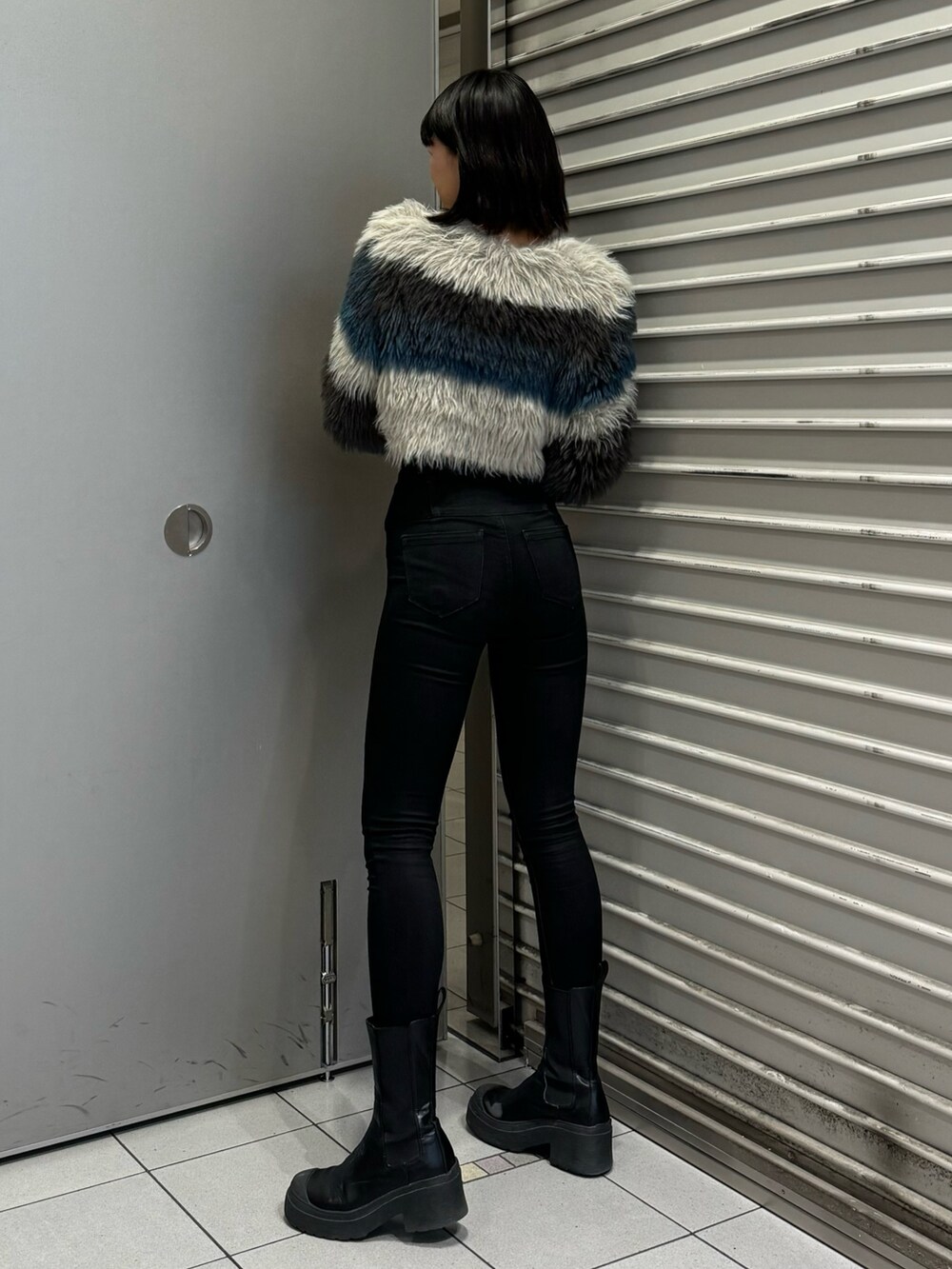 ブラック系のブーツ、ブラック系のデニムパンツ、その他のニット/セーターを着用したレディースの秋コーディネートの4枚目の写真