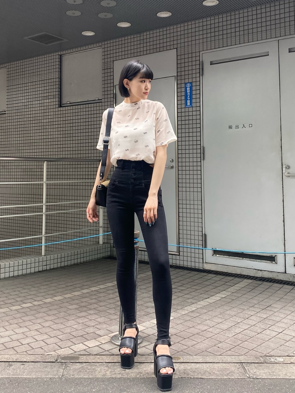 ブラック系のサンダル、ブラック系のデニムパンツ、ホワイト系のTシャツ/カットソーを着用したレディースの夏コーディネートの2枚目の写真