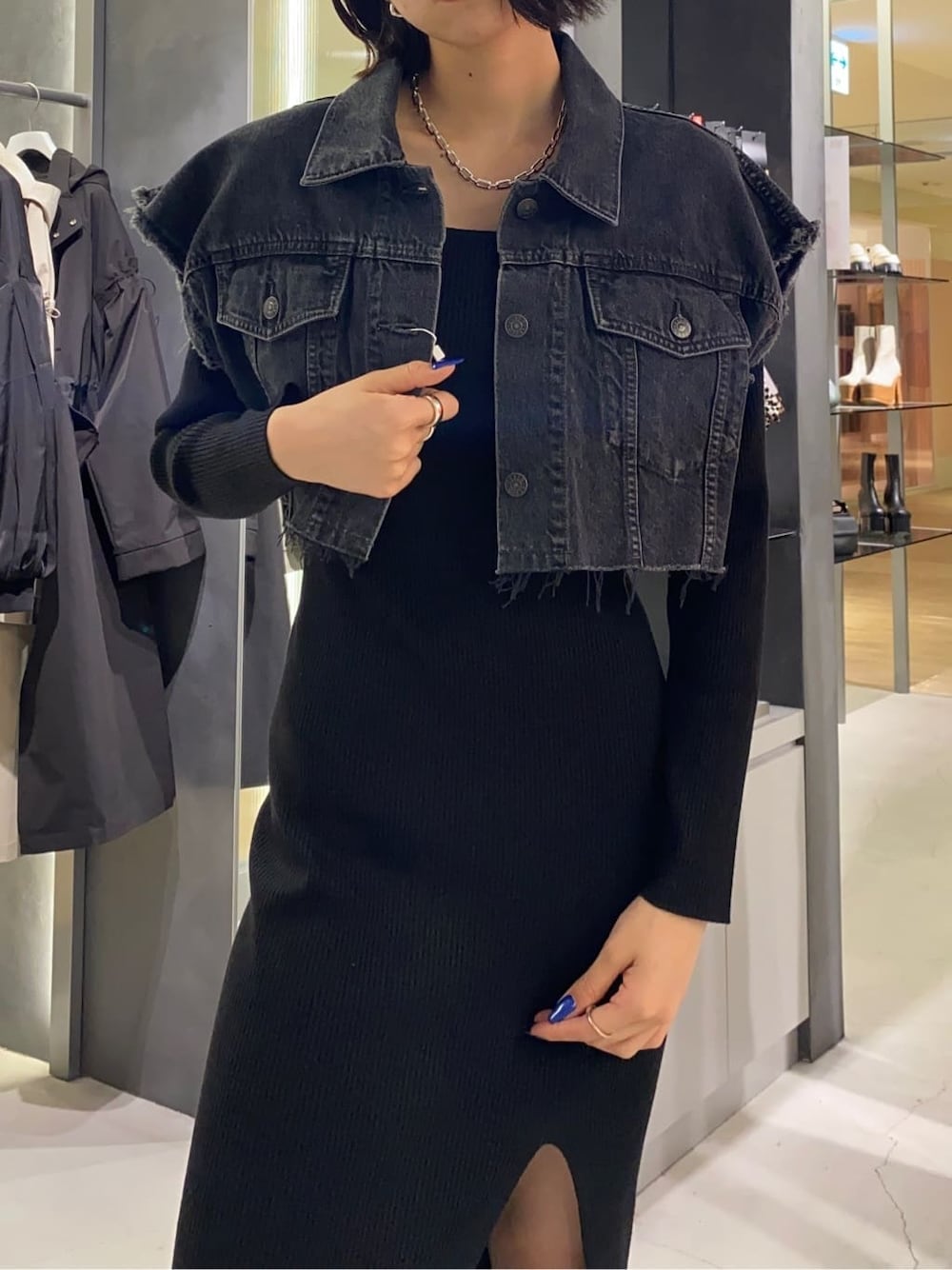 ブラック系のブーツ、ブラック系のワンピース、ブラウン系のハンドバッグを着用したレディースの秋コーディネートの3枚目の写真