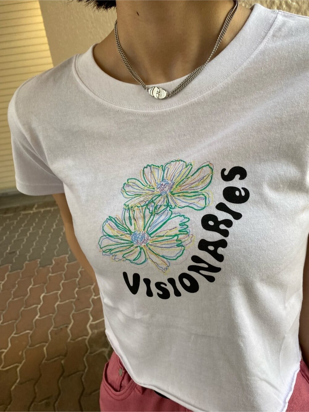 ピンク系のデニムパンツ、ブラック系のハンドバッグ、ホワイト系のTシャツ/カットソーを着用したレディースの夏コーディネートの3枚目の写真