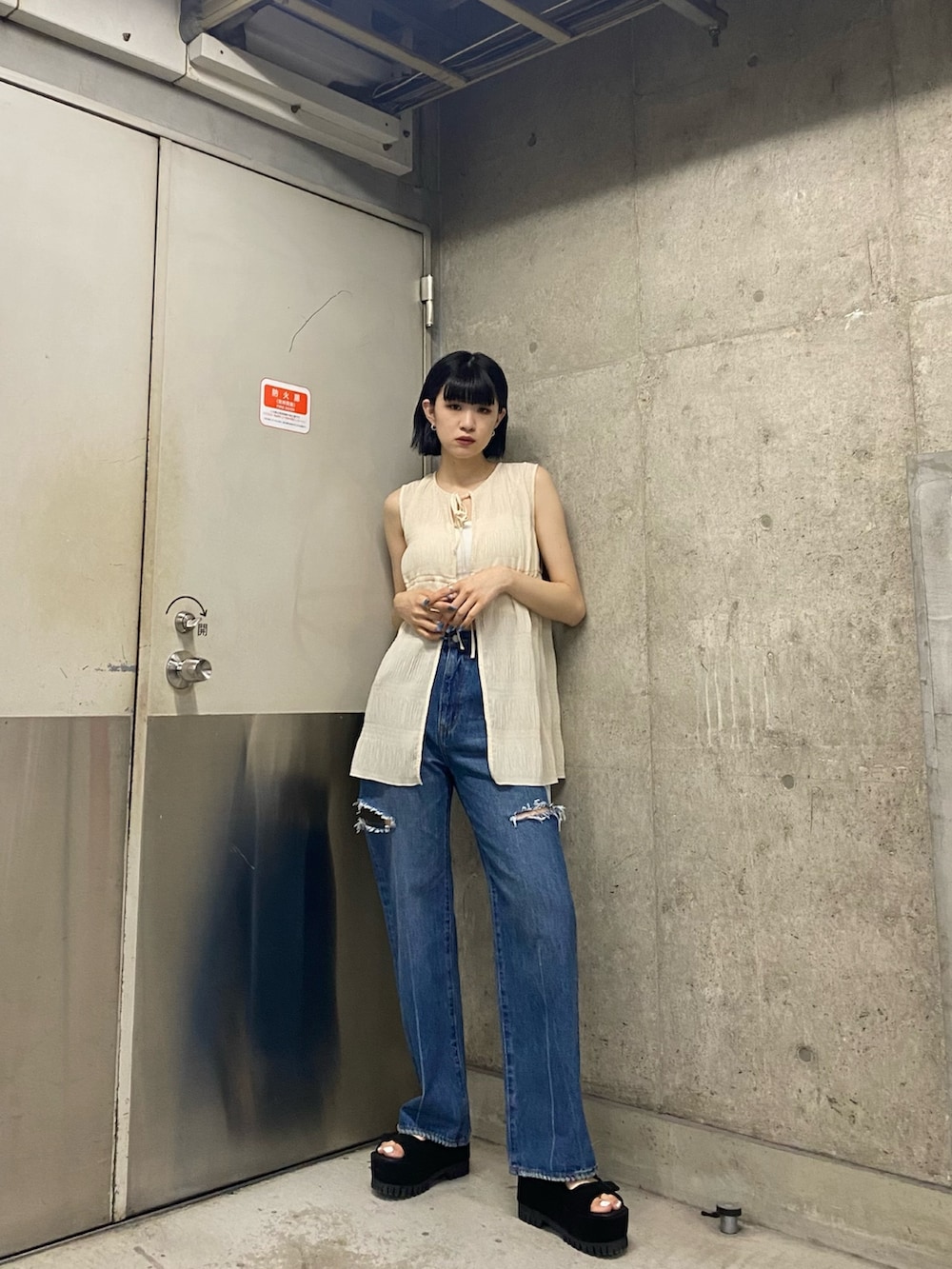 ブラック系のサンダル、ブルー系のデニムパンツ、ホワイト系のTシャツ/カットソーを着用したレディースの夏コーディネートの2枚目の写真