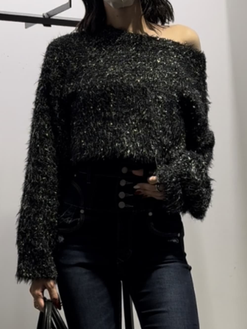 ブラック系のハンドバッグ、ブラック系のニット/セーター、ブルー系のデニムパンツを着用したレディースの冬コーディネートの10枚目の写真