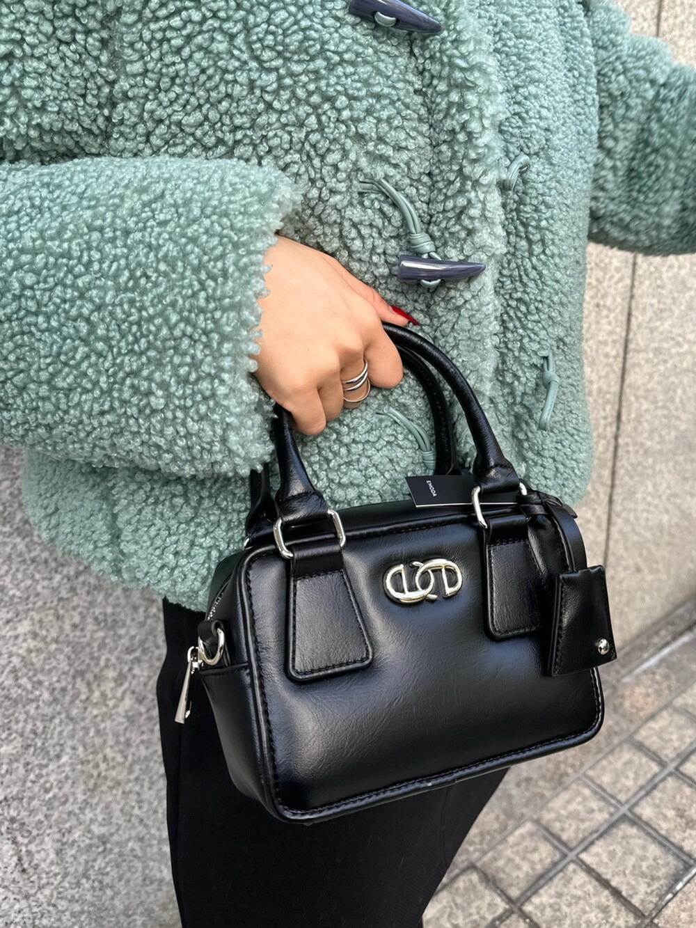 グリーン系のブルゾン、ブラック系のスカート、その他のブーツを着用したレディースの冬コーディネートの10枚目の写真