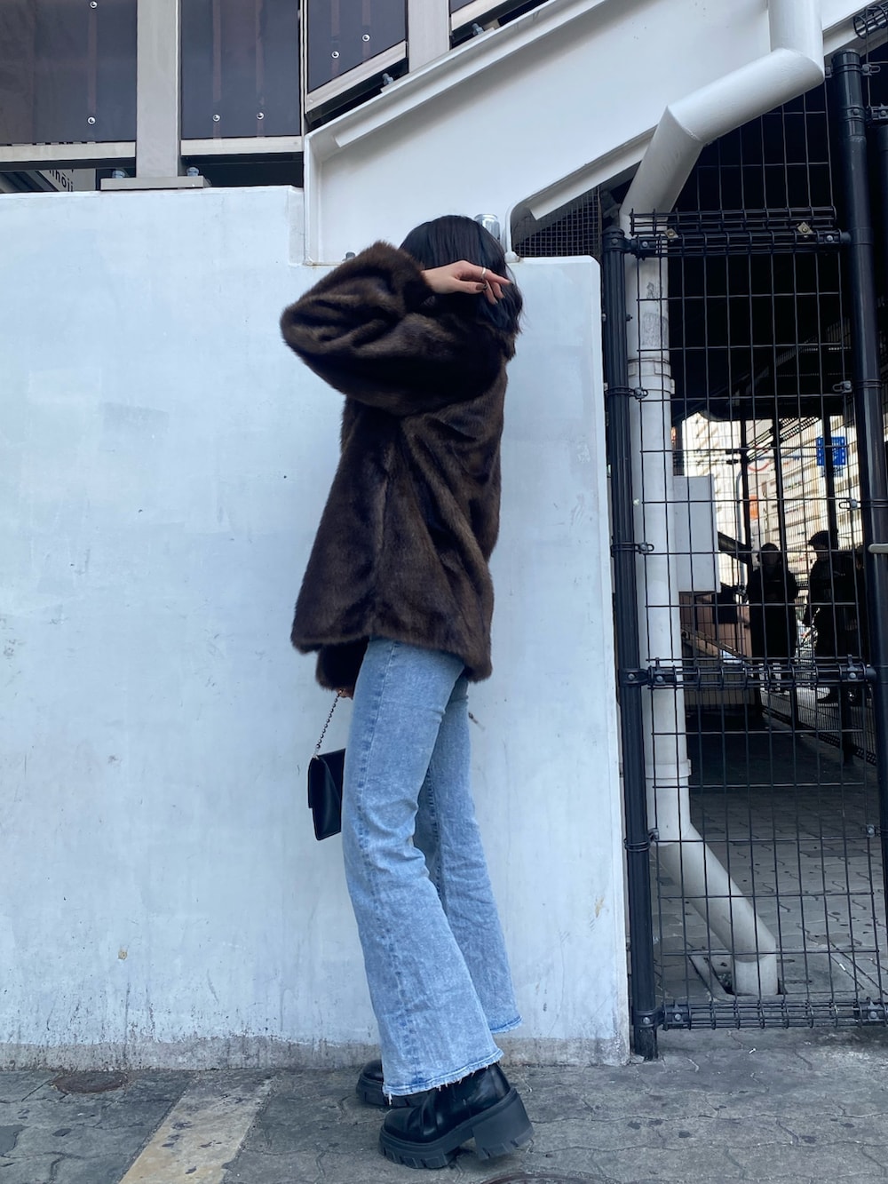 ブルー系のデニムパンツ、ブラック系のブーツ、ブラウン系のその他アウターを着用したレディースの冬コーディネートの5枚目の写真