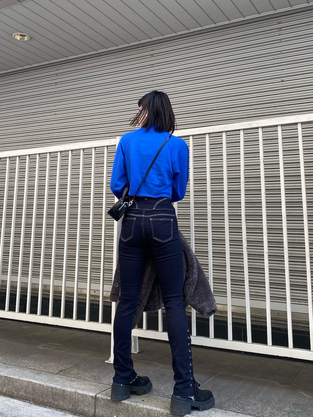 ブルー系のデニムパンツ、ブラック系のブーツ、ブルー系のスウェットを着用したレディースの冬コーディネートの5枚目の写真