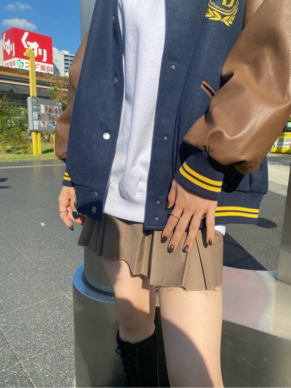 ブラック系のブーツ、ブルー系のブルゾン、ベージュ系のスカートを着用したレディースの秋コーディネートの5枚目の写真