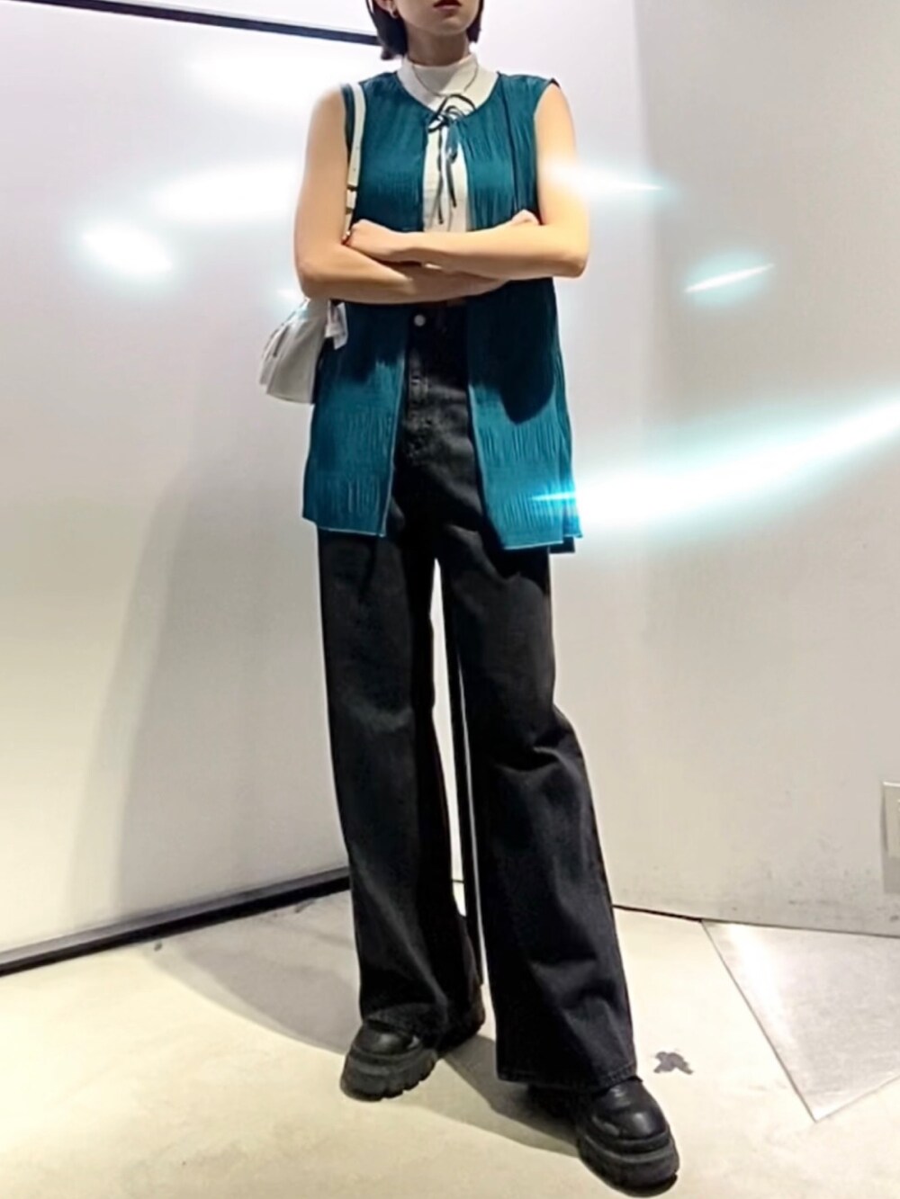 ブラック系のブーツ、ホワイト系のハンドバッグ、ブルー系のTシャツ/カットソーを着用したレディースの夏コーディネートの2枚目の写真