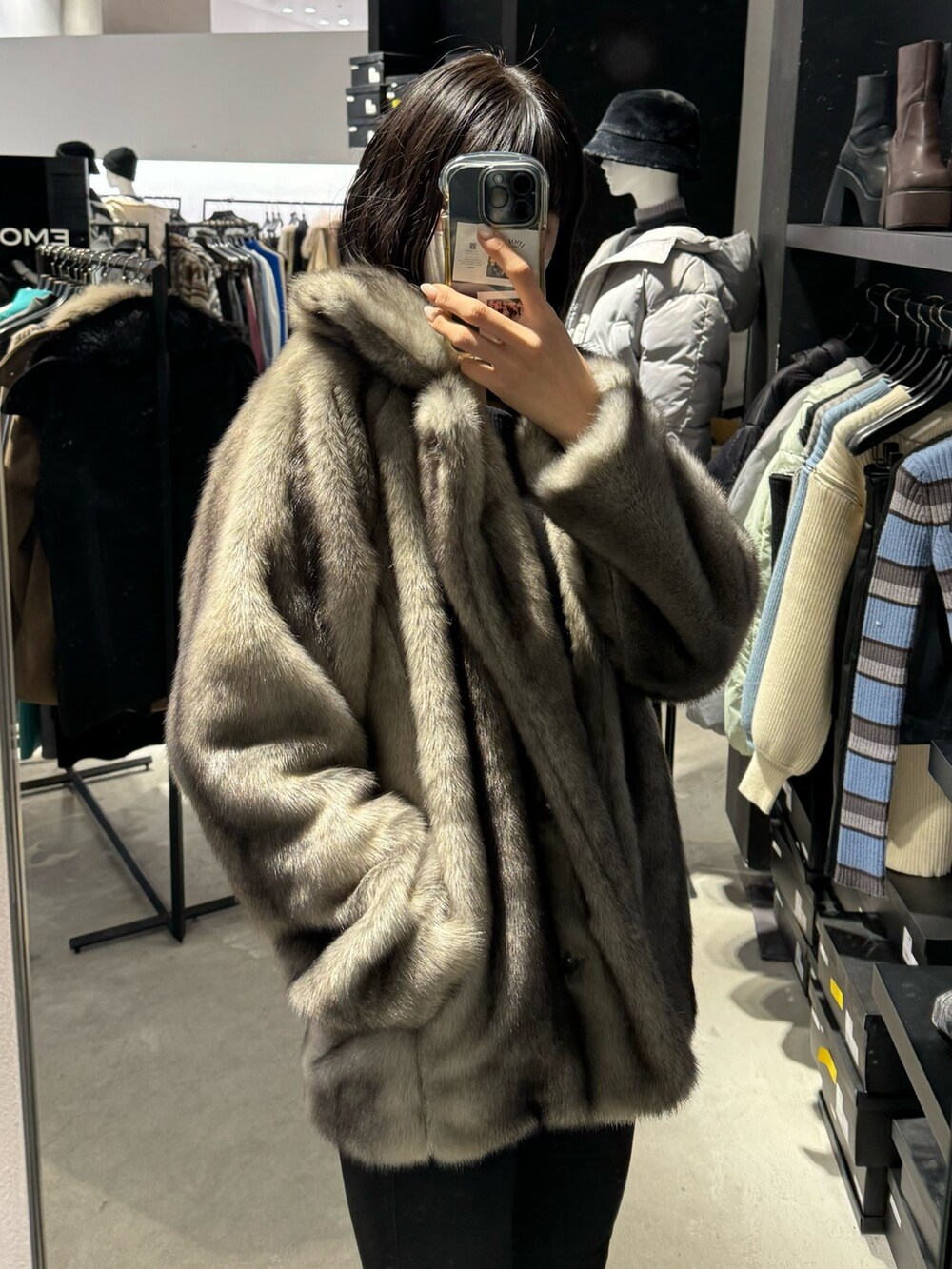 ブラック系のブーツ、ブラック系のデニムパンツ、グレー系のその他アウターを着用したレディースの冬コーディネートの4枚目の写真