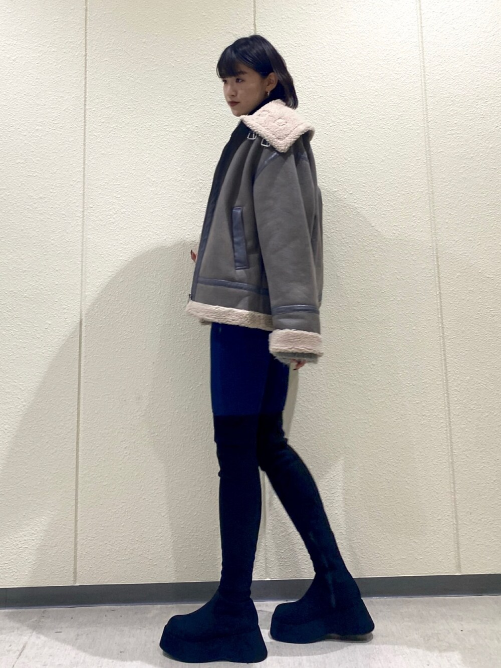 ブルー系のデニムパンツ、グレー系のブルゾン、ブラック系のニット/セーターを着用したレディースの冬コーディネートの5枚目の写真