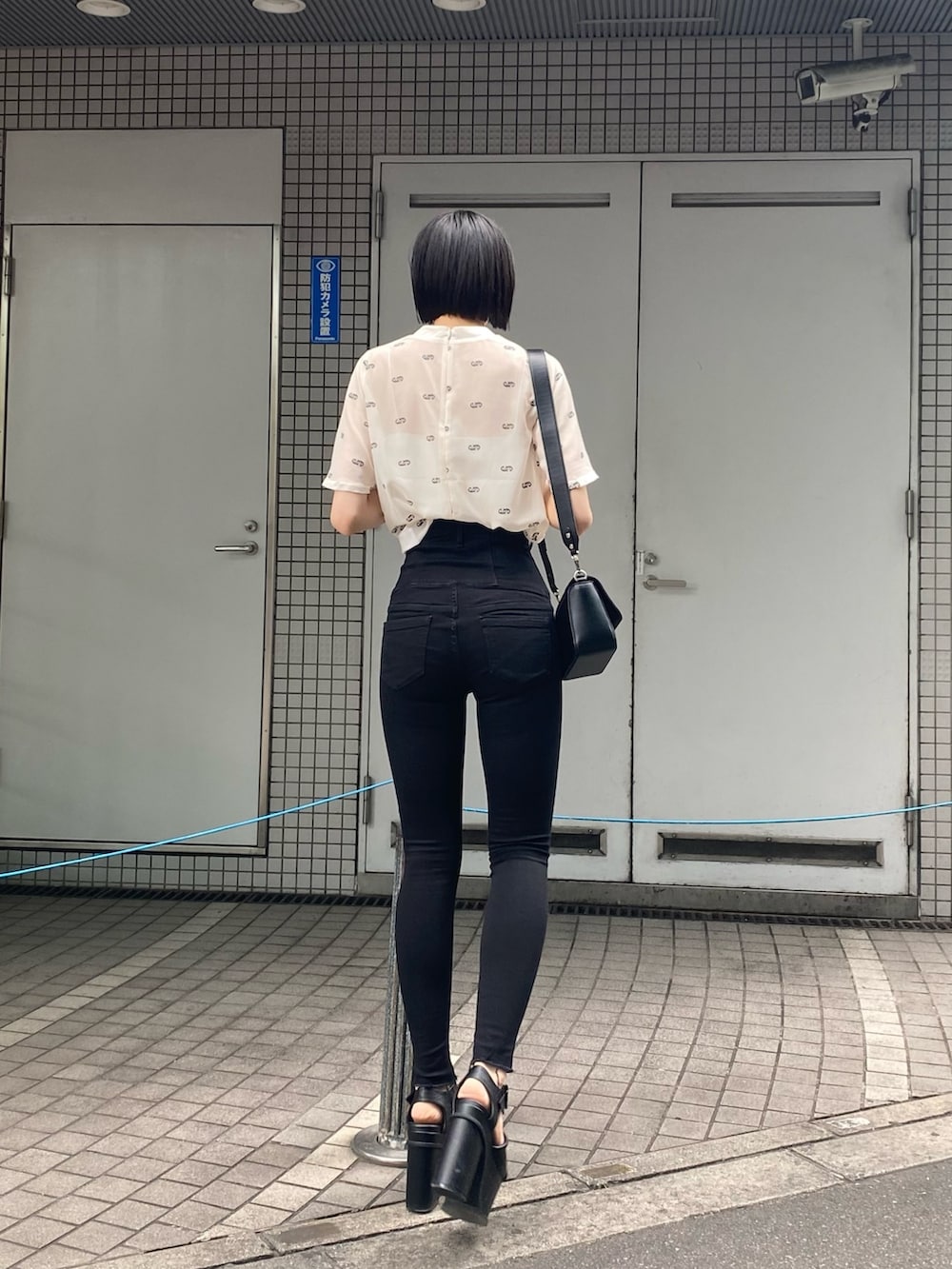 ブラック系のサンダル、ブラック系のデニムパンツ、ホワイト系のTシャツ/カットソーを着用したレディースの夏コーディネートの4枚目の写真