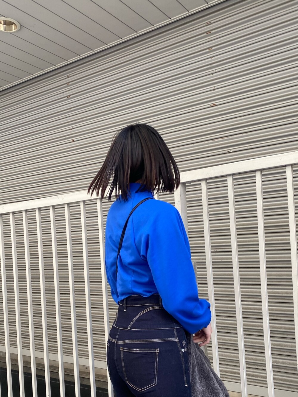 ブルー系のデニムパンツ、ブラック系のブーツ、ブルー系のスウェットを着用したレディースの冬コーディネートの9枚目の写真