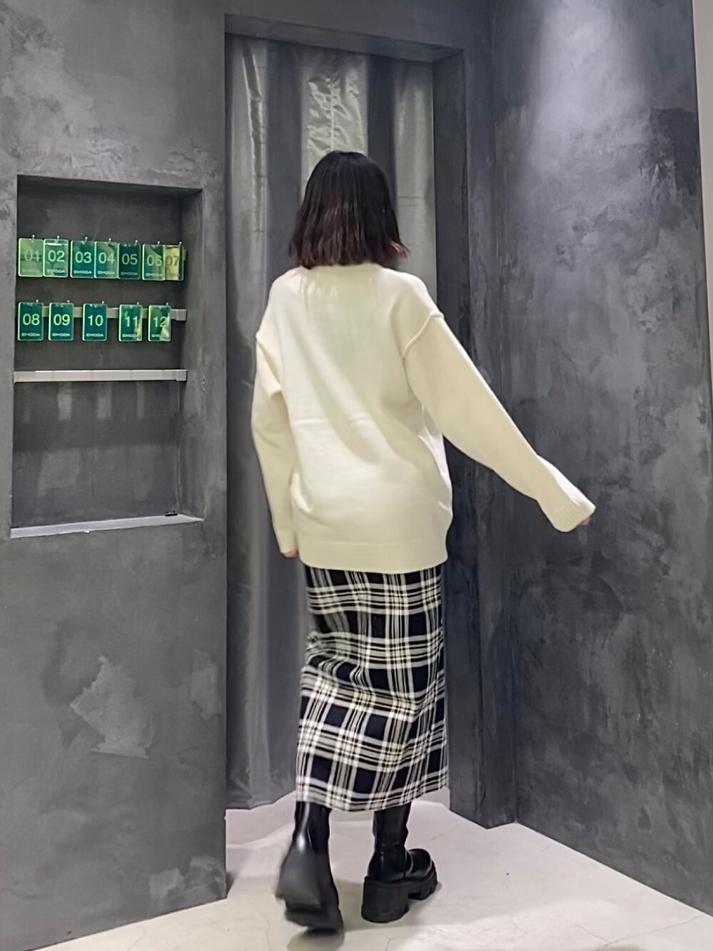 その他のスカート、ホワイト系のニット/セーター、ブラック系のブーツを着用したレディースの冬コーディネートの4枚目の写真