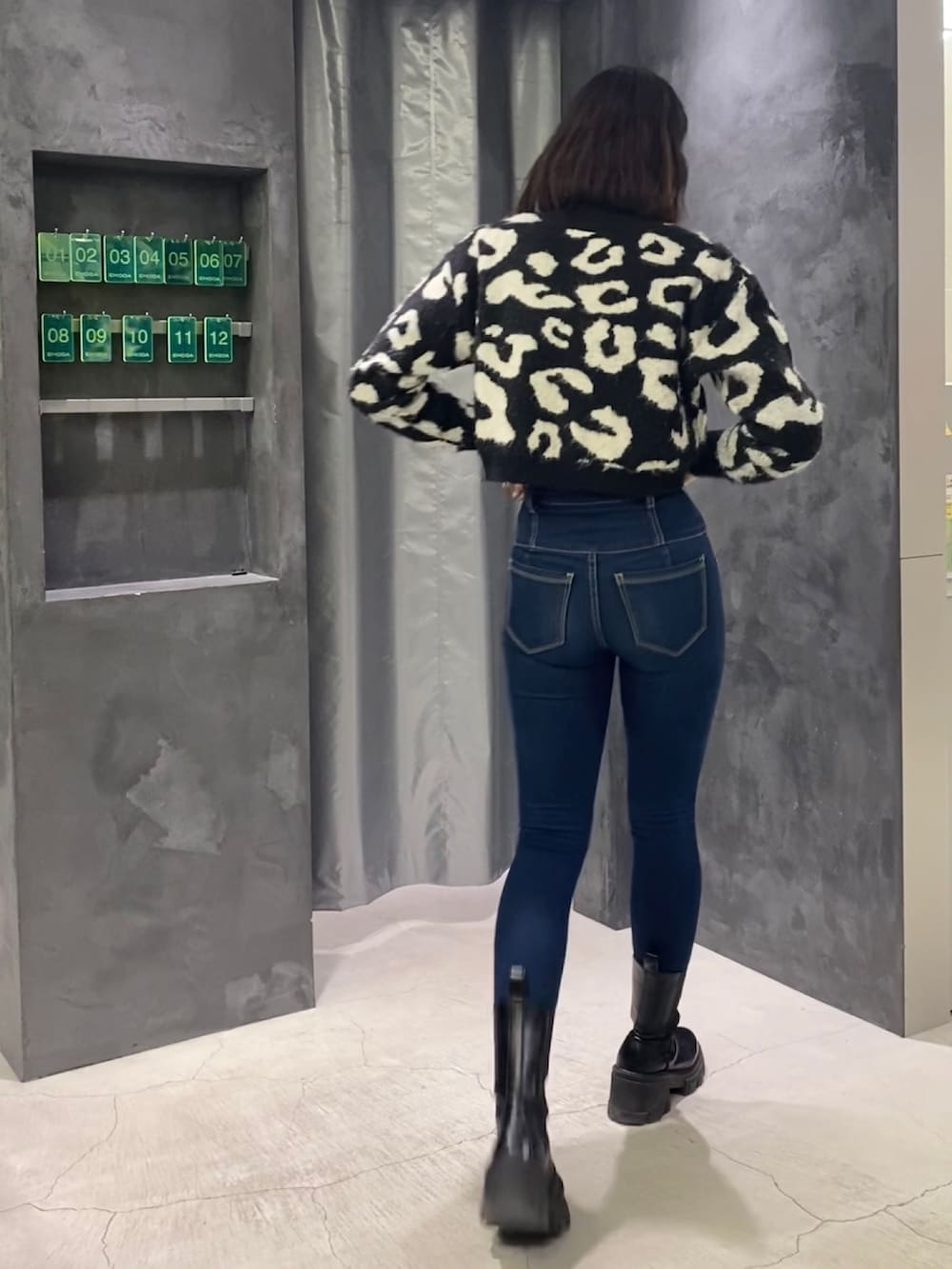 ブルー系のデニムパンツ、ブラック系のブーツ、ブラック系のカーディガン/ボレロを着用したレディースの冬コーディネートの3枚目の写真