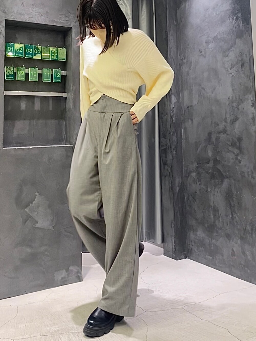 ブラック系のブーツ、グレー系のその他パンツ、ホワイト系のニット/セーターを着用したレディースの冬コーディネートの2枚目の写真