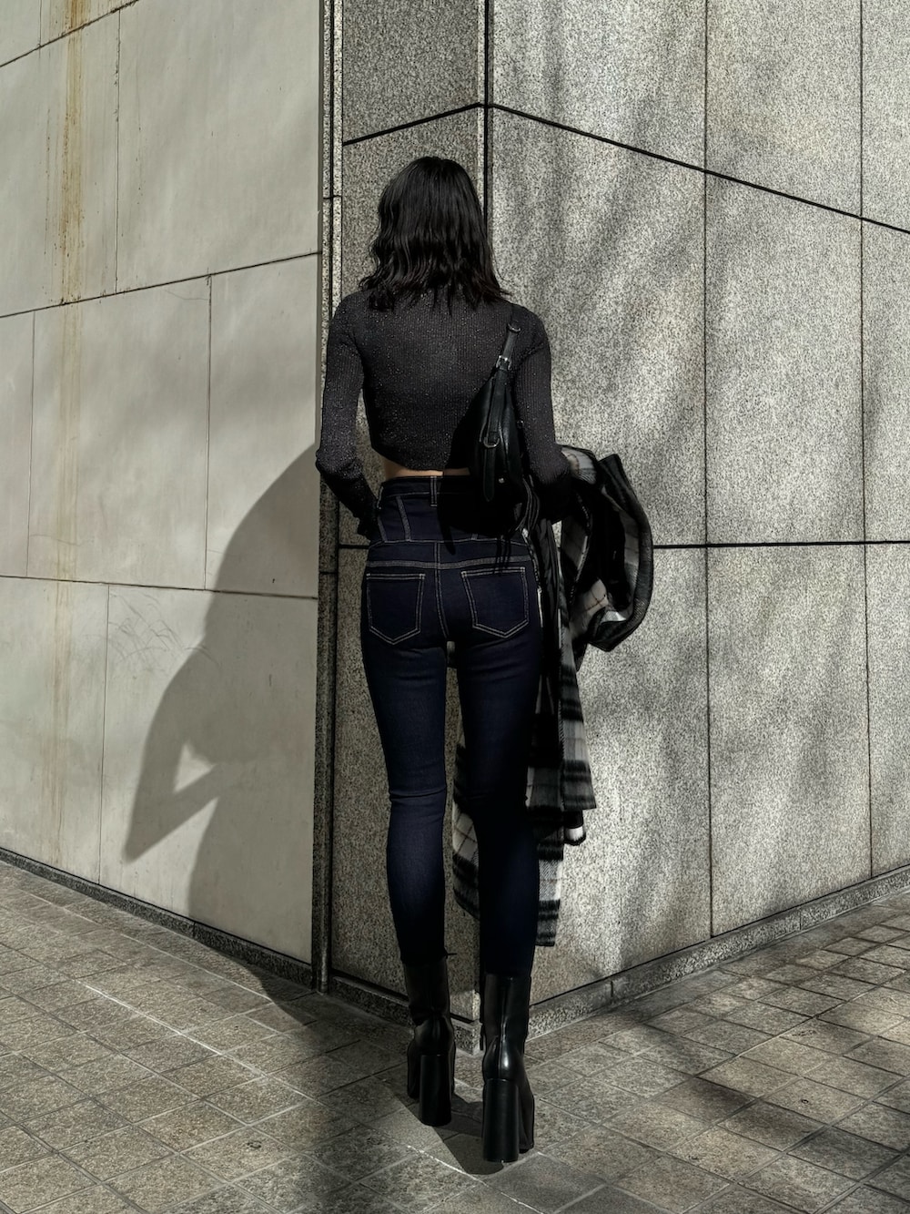 ブラック系のブーツ、ブルー系のデニムパンツ、その他のチェスターコートを着用したレディースの冬コーディネートの7枚目の写真