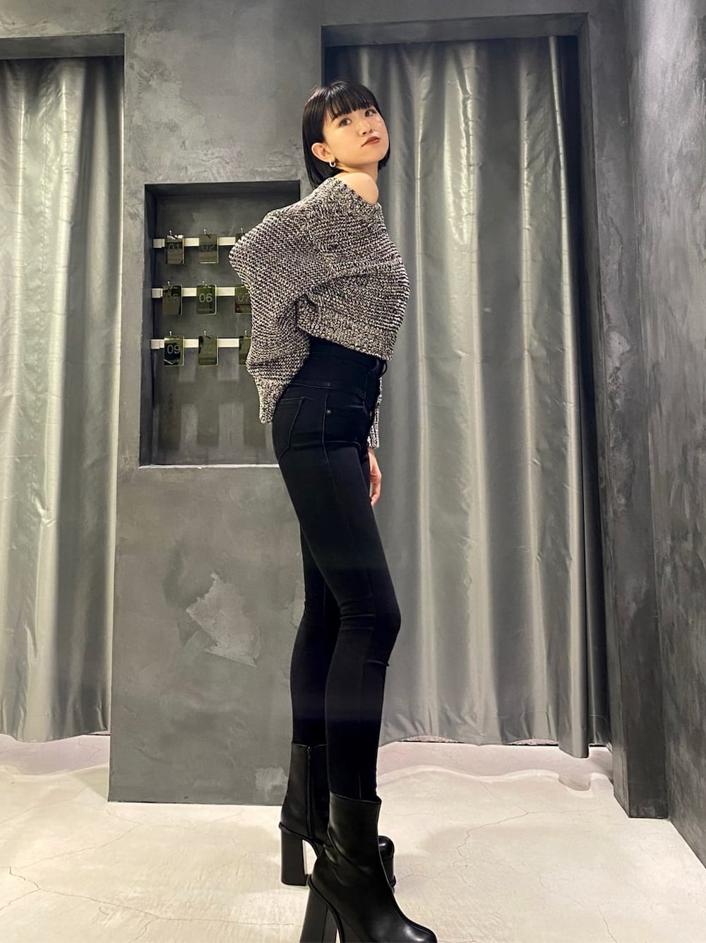 ブラック系のデニムパンツ、ブラック系のデニムパンツ、ブラック系のブーツを着用したレディースの秋コーディネートの2枚目の写真
