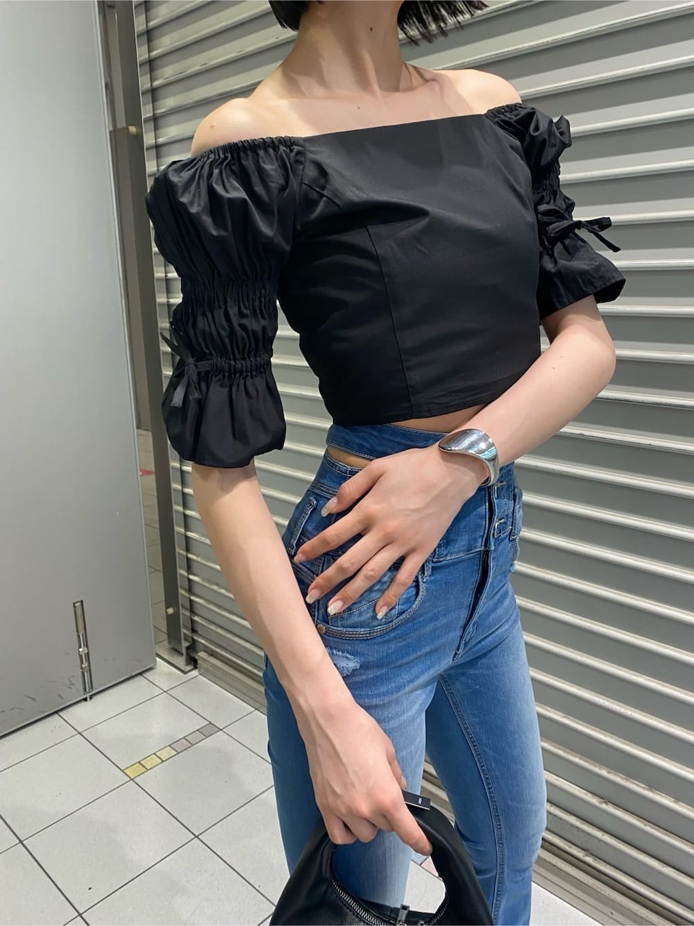 ブルー系のデニムパンツ、ブラック系のサンダル、ブラック系のシャツ/ブラウスを着用したレディースの夏コーディネートの3枚目の写真