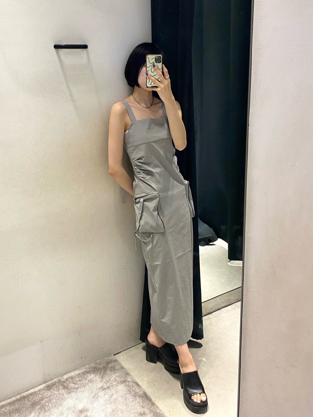 グレー系のワンピース、ブラック系のサンダル、ホワイト系のキャミソールを着用したレディースの夏コーディネートの3枚目の写真