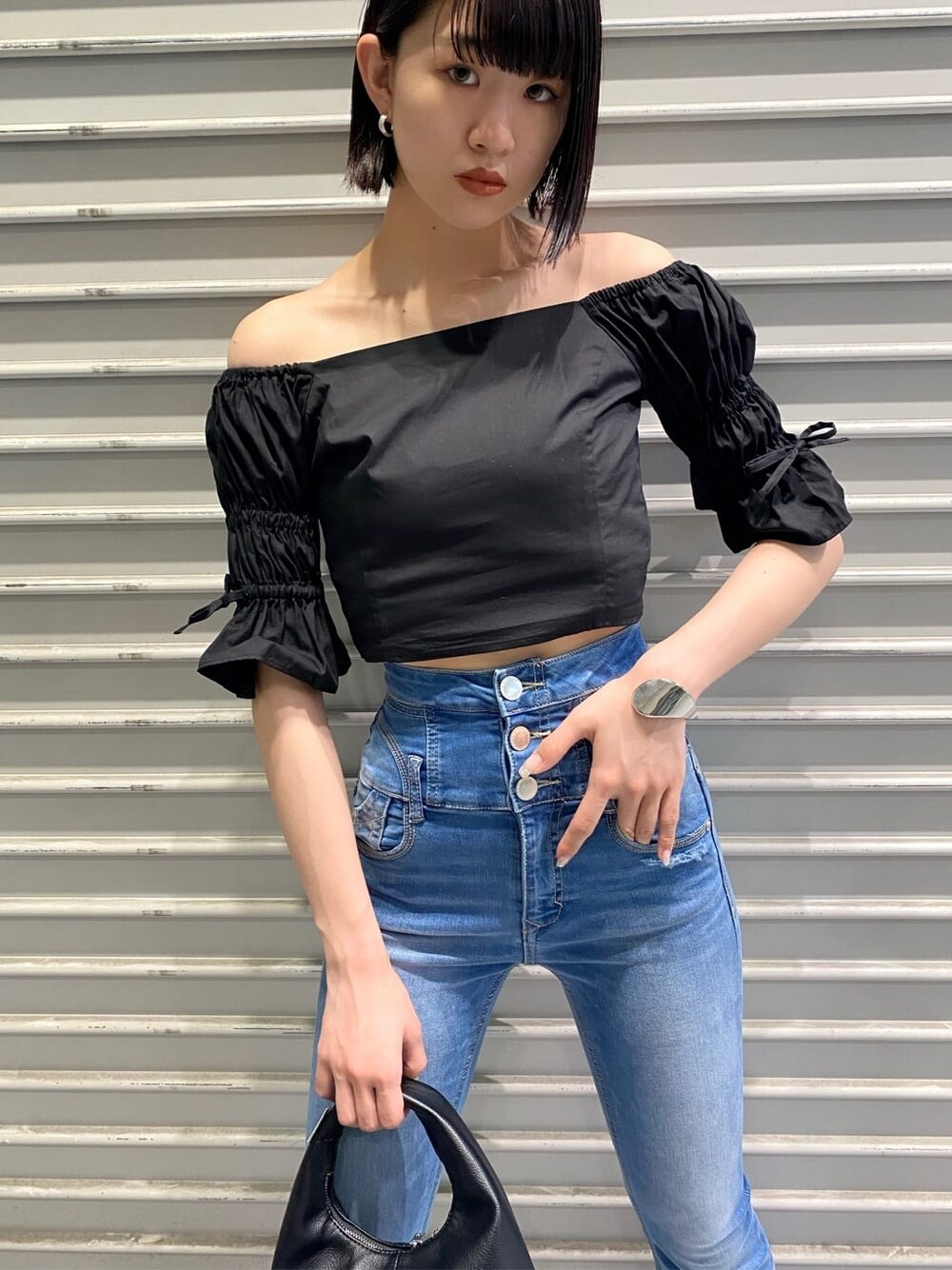 ブルー系のデニムパンツ、ブラック系のサンダル、ブラック系のシャツ/ブラウスを着用したレディースの夏コーディネートの7枚目の写真