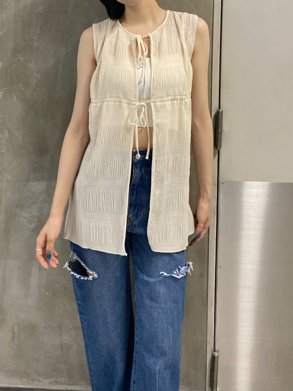 ブラック系のサンダル、ブルー系のデニムパンツ、ホワイト系のTシャツ/カットソーを着用したレディースの夏コーディネートの10枚目の写真