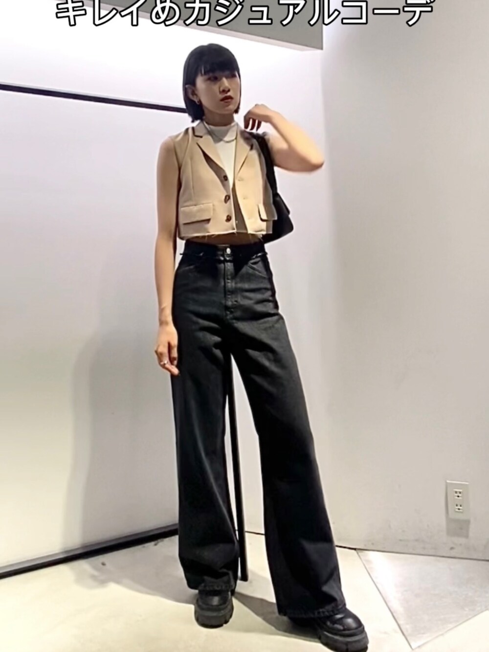 ブラック系のデニムパンツ、ブラック系のブーツ、ブラック系のショルダーバッグを着用したレディースの夏コーディネートの3枚目の写真