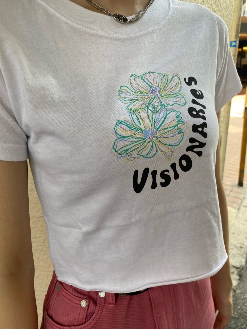 ピンク系のデニムパンツ、ブラック系のハンドバッグ、ホワイト系のTシャツ/カットソーを着用したレディースの夏コーディネートの4枚目の写真