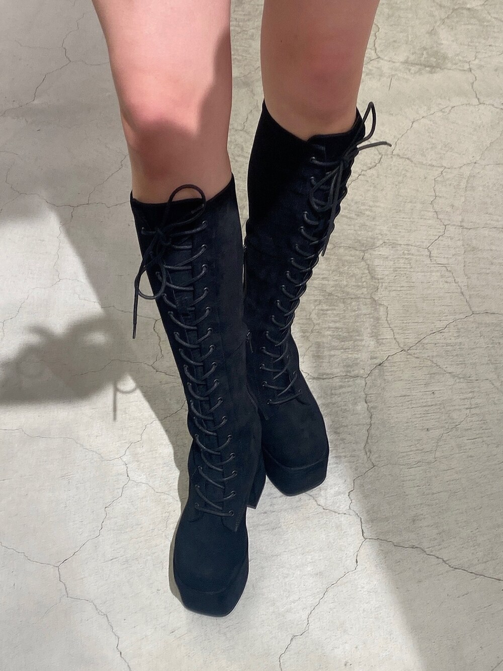 ブラック系のスカート、ブラック系のブーツ、グレー系のブルゾンを着用したレディースの冬コーディネートの8枚目の写真