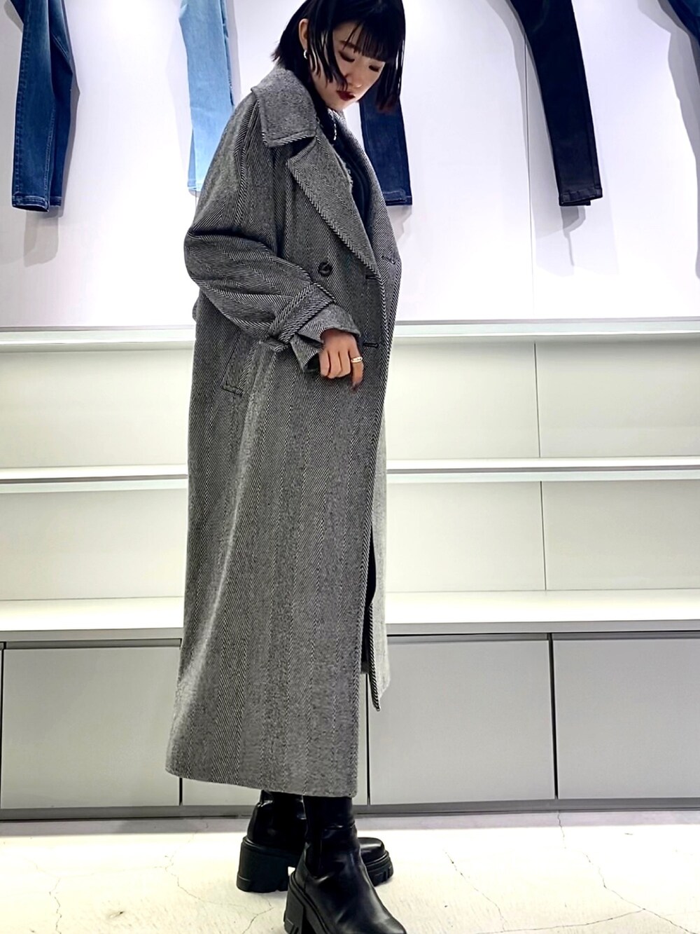 その他のチェスターコート、ブラック系のブーツ、ブラック系のニット/セーターを着用したレディースの秋コーディネートの3枚目の写真