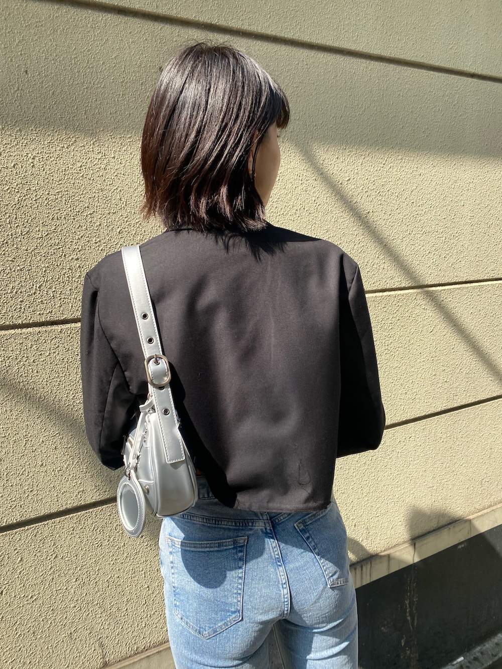 ブラック系のブーツ、ブルー系のデニムパンツ、ブラック系のTシャツ/カットソーを着用したレディースの春コーディネートの9枚目の写真