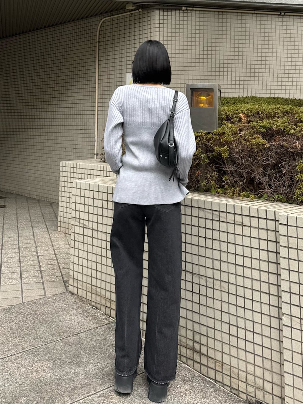 ブラック系のブーツ、ブラック系のデニムパンツ、グレー系のニット/セーターを着用したレディースの冬コーディネートの3枚目の写真