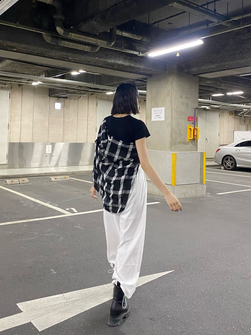 ホワイト系のその他パンツ、ブラック系のブーツ、ブラック系のTシャツ/カットソーを着用したレディースの春コーディネートの5枚目の写真