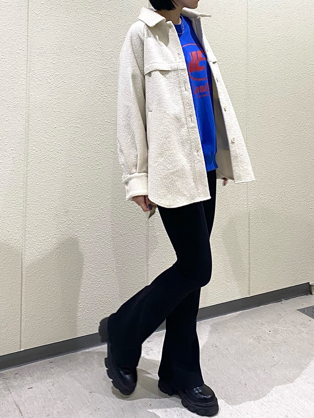 ホワイト系のブルゾン、ブラック系のその他パンツ、ブラック系のブーツを着用したレディースの冬コーディネートの4枚目の写真