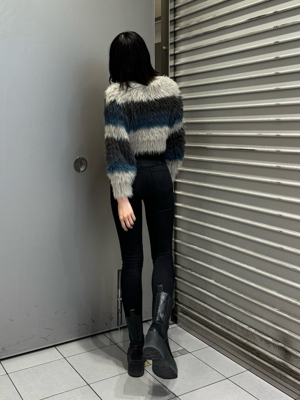 ブラック系のブーツ、ブラック系のデニムパンツ、その他のニット/セーターを着用したレディースの秋コーディネートの3枚目の写真