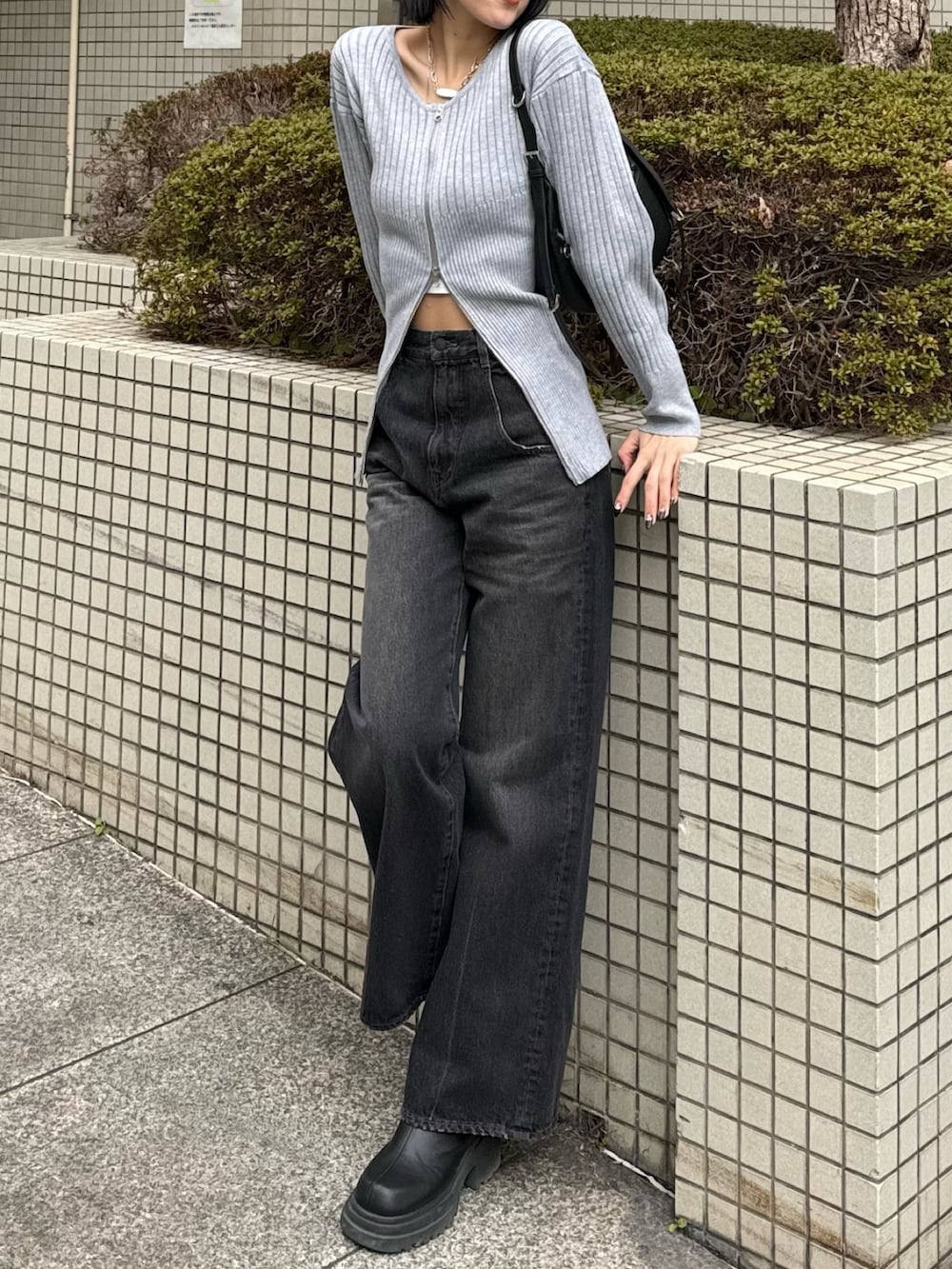 ブラック系のブーツ、ブラック系のデニムパンツ、グレー系のニット/セーターを着用したレディースの冬コーディネートの4枚目の写真