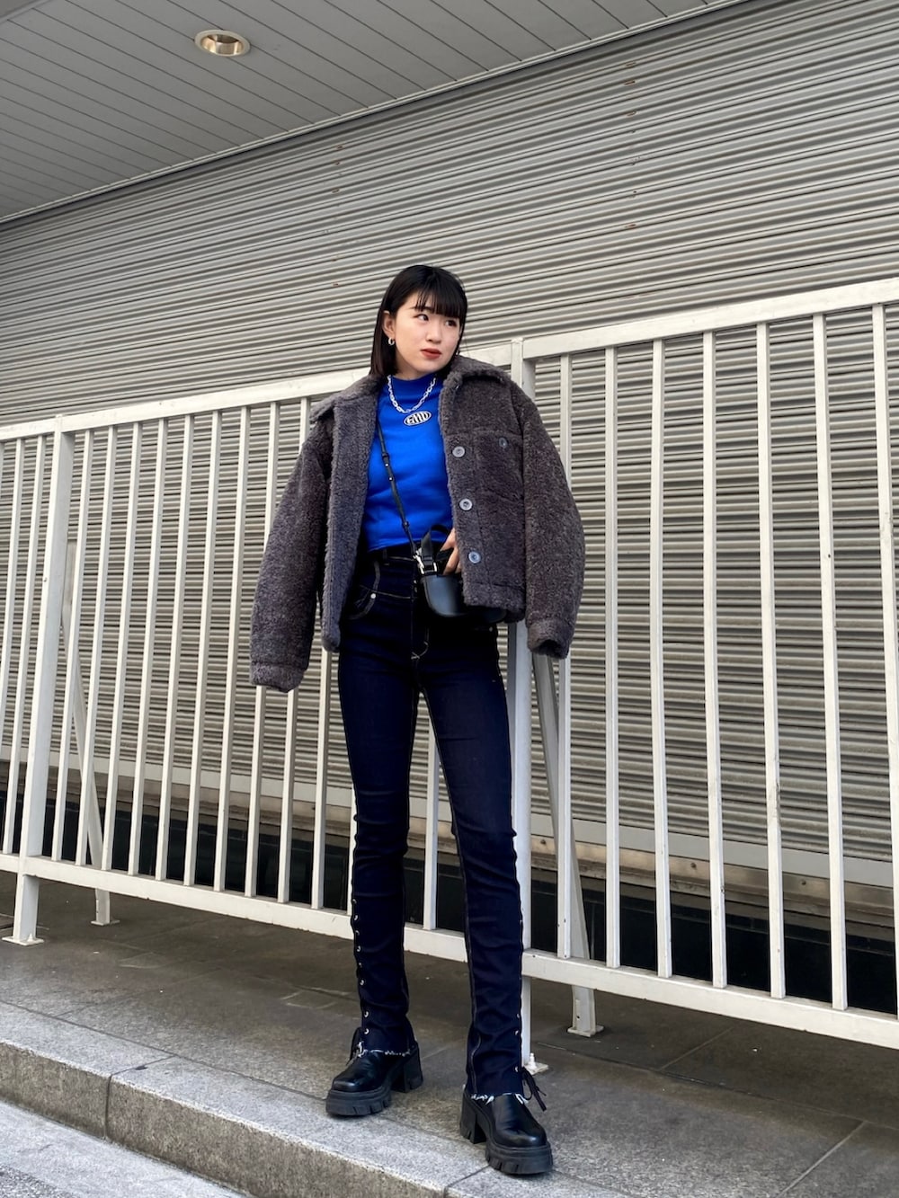 ブルー系のデニムパンツ、ブラック系のブーツ、ブルー系のスウェットを着用したレディースの冬コーディネートの3枚目の写真