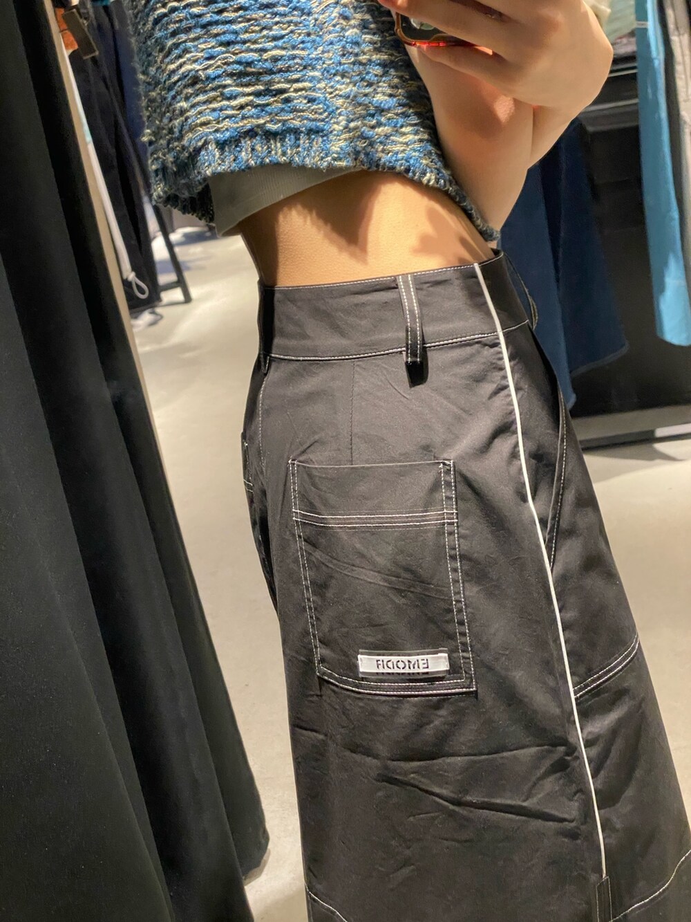 ブラック系のサンダル、ブラック系のスカート、ブルー系のベストを着用したレディースの夏コーディネートの8枚目の写真